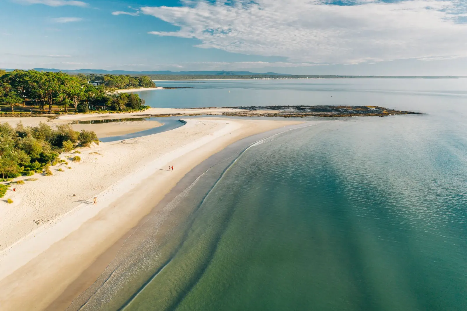 Aerial view of the white sand and clear green water of Jervis Bay, NSW